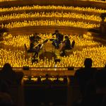 String quartet performing surrounded by thousands of candles